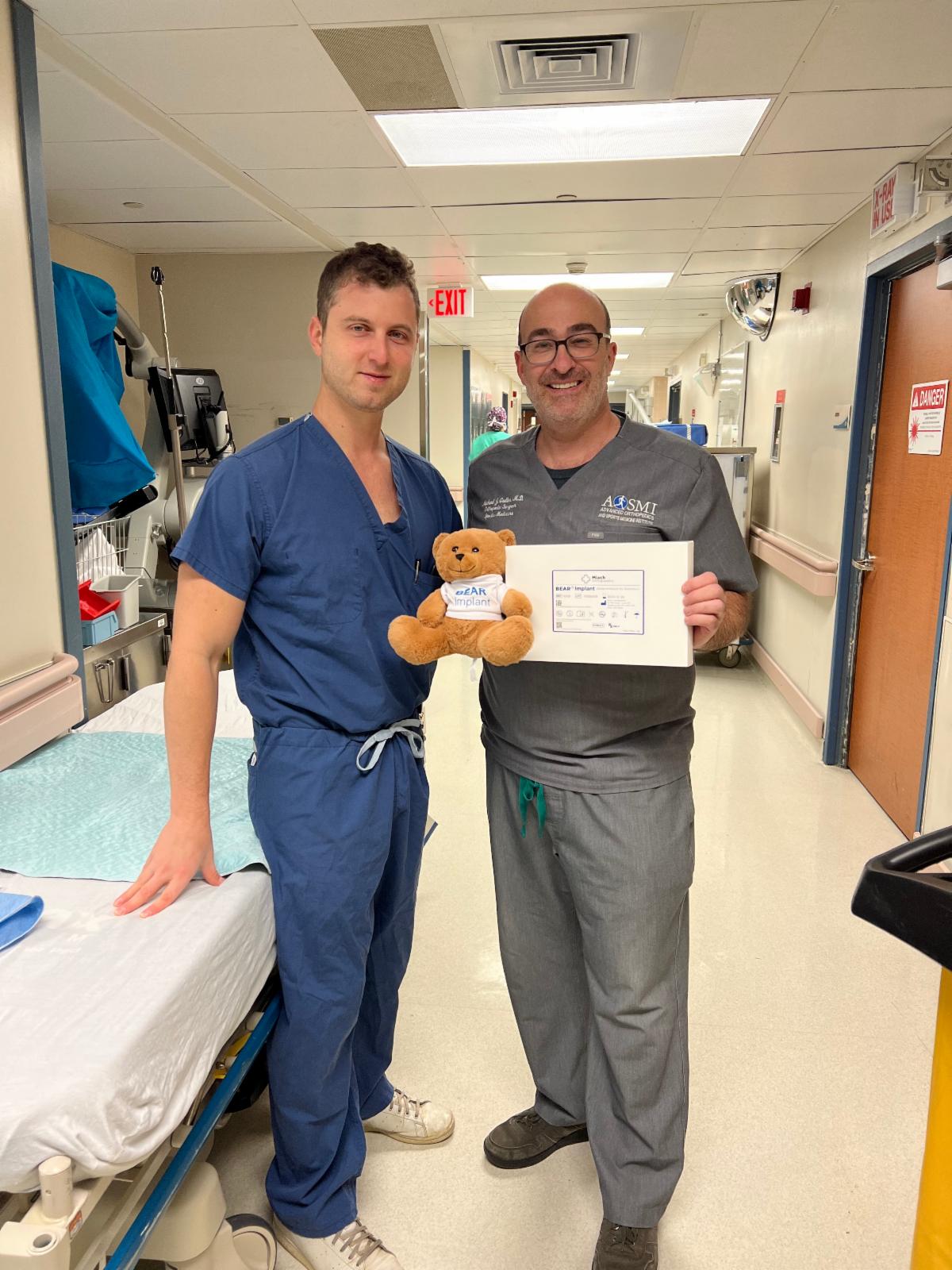 Michael J. Greller, MD, MBA, CPE, FAAOS and Garret L. Sobol, MD holding the BEAR Implant and the BEAR stuffed teddy bear mascot 