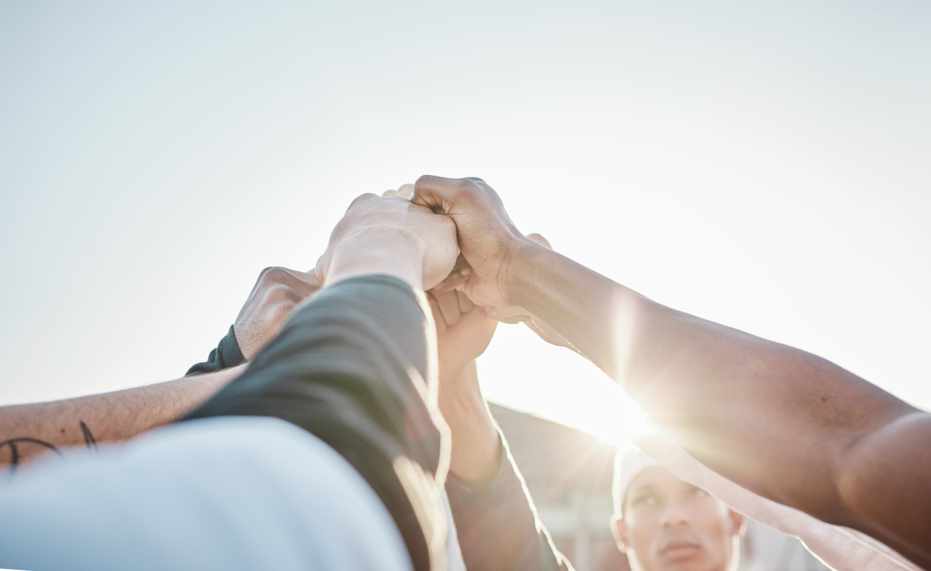 Team of baseball players hands-in before a game. Team has had a player who has been injured from repetitive overuse overhead pitching throws. He has recovered from shoulder instability and torn labrum surgery