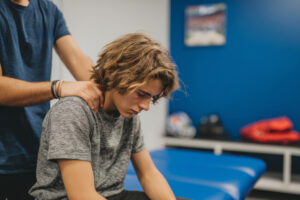 Physical therapist working with athlete on movement training for sports.