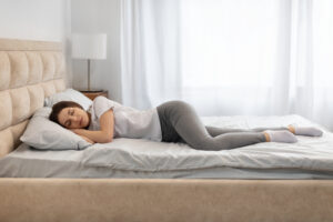 Side sleeper showing knee and hip position while sleeping without a pillow between the knees