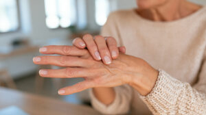 Adult gently moving stiff fingers after waking in the morning