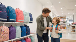 Parent helping a child choose a properly fitted school backpack