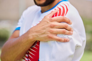 Athlete holding his shoulder due to pain or discomfort.